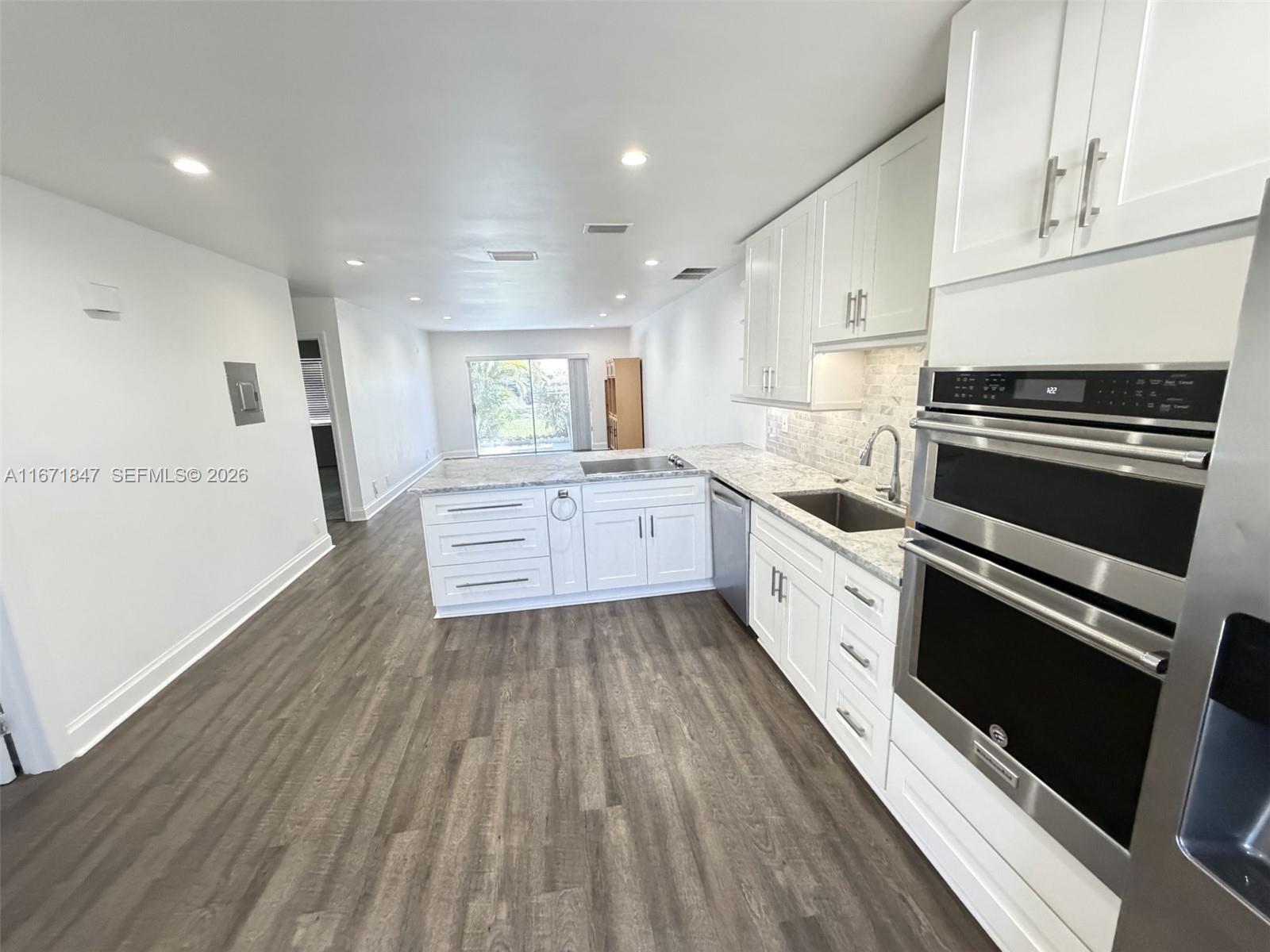 20927 Sedgewick Drive Boca Raton, FL 33433 - Photo 6 of 24 a large kitchen with a lot of white cabinets and stainless steel appliances