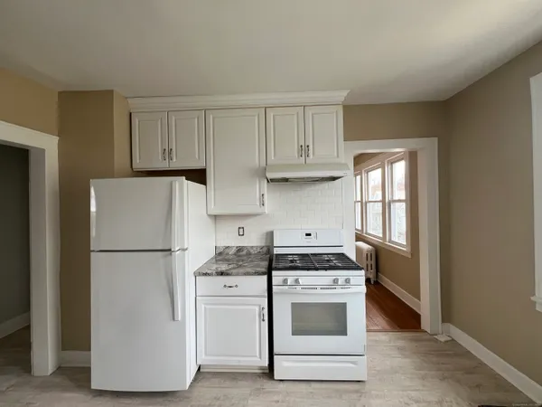 a kitchen with a white stove top oven and refrigerator