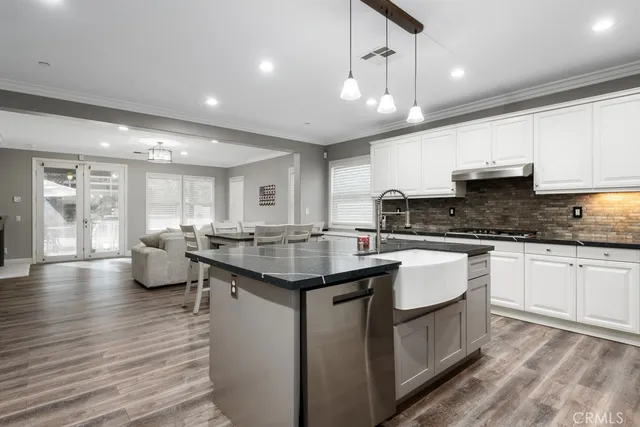 a kitchen with stainless steel appliances granite countertop a lot of counter space and wooden floors