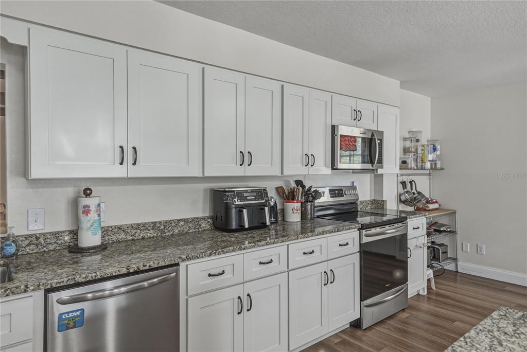 609 West Pipkin Road Lakeland, FL 33813 - Photo 18 of 72 a kitchen with stainless steel appliances granite countertop white cabinets sink and dishwasher