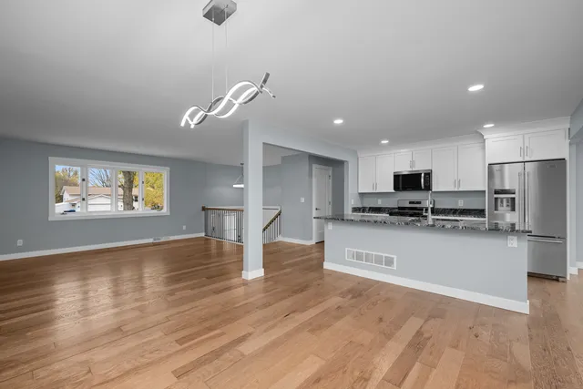 a view of kitchen with cabinets microwave and stove