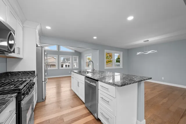 a kitchen with granite countertop a sink stove and cabinets