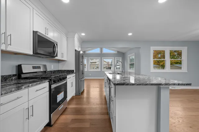 a kitchen with stainless steel appliances granite countertop a sink and stove top oven