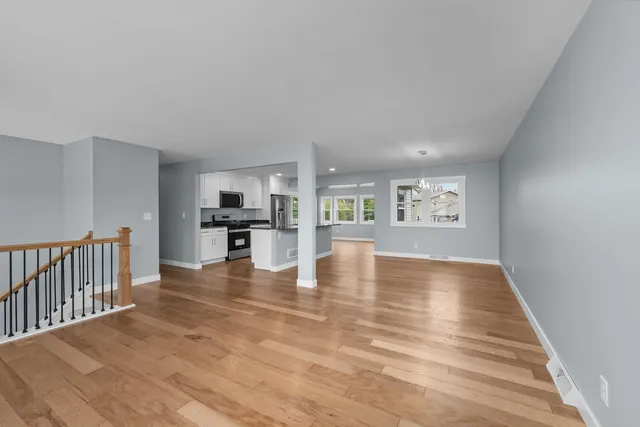 a view of kitchen with kitchen island microwave and wooden floor