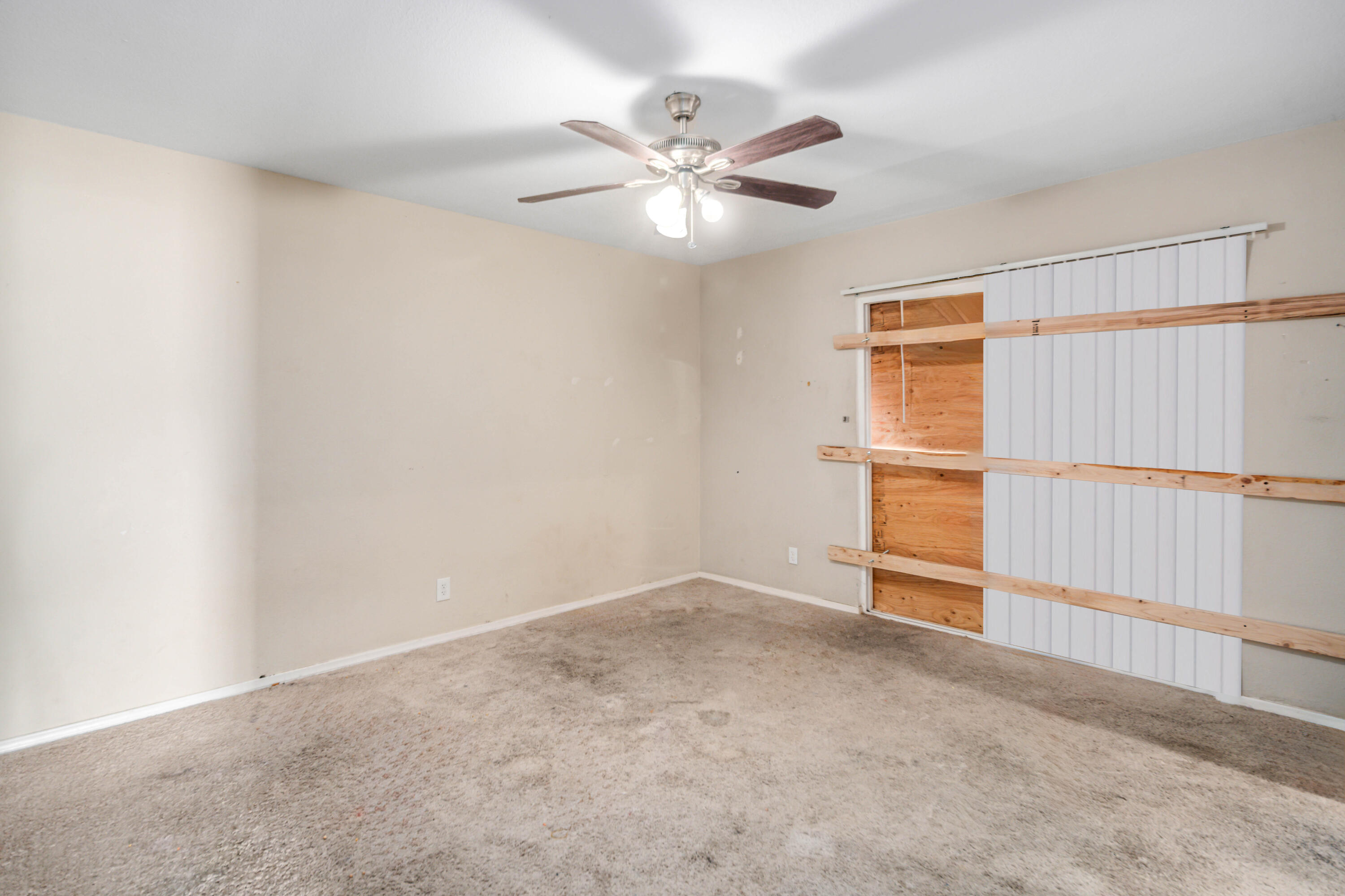 621 Ave J E Lancaster Ca East Lancaster, CA 93535 - Photo 15 of 25 an empty room with windows and fan