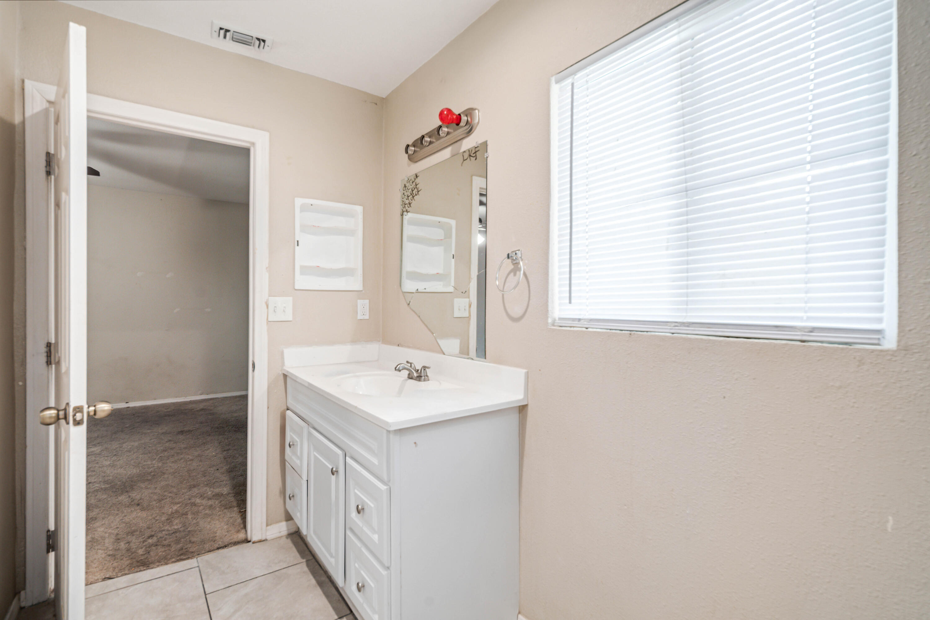 621 Ave J E Lancaster Ca East Lancaster, CA 93535 - Photo 18 of 25 a bathroom with a sink a vanity and a mirror