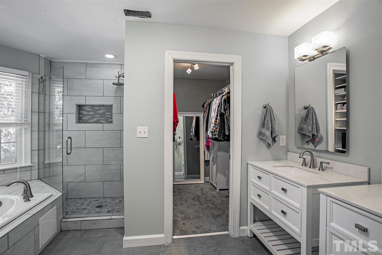 11503 South Lowell Road Bahama, NC 27503 - Photo 11 of 30 Beautiful finishes chosen for the bathroom updates; dual granite vanities, tile floors, frameless shower door, backlit vanity mirrors, shower niche, and more!