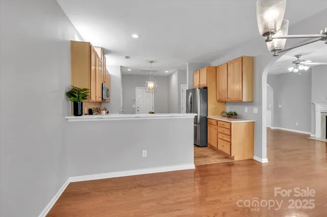 a view of kitchen and kitchen with stainless steel appliances wooden floor