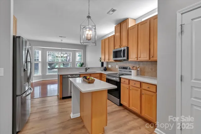 a kitchen with stainless steel appliances granite countertop a stove a sink dishwasher and a refrigerator