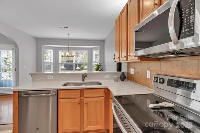 a kitchen with stainless steel appliances granite countertop a sink and a stove