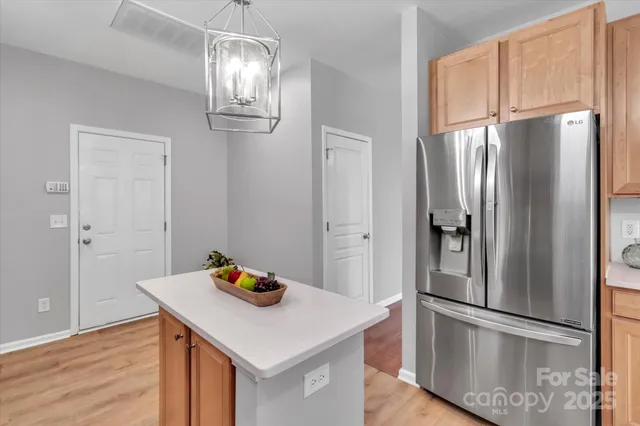 a kitchen with stainless steel appliances a refrigerator and wooden floor