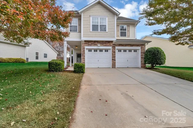 a front view of a house with a yard and trees