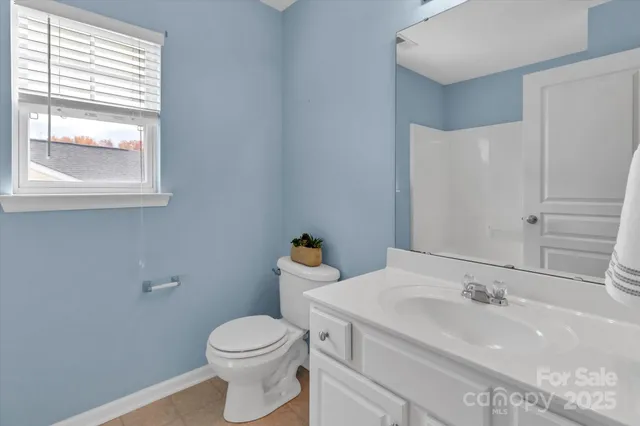 a bathroom with a sink a toilet and a window