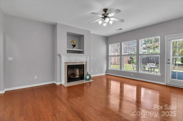 a view of an empty room with a fireplace and a window