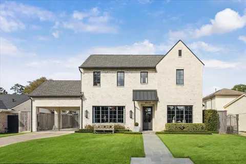 a front view of a house with a yard and trees
