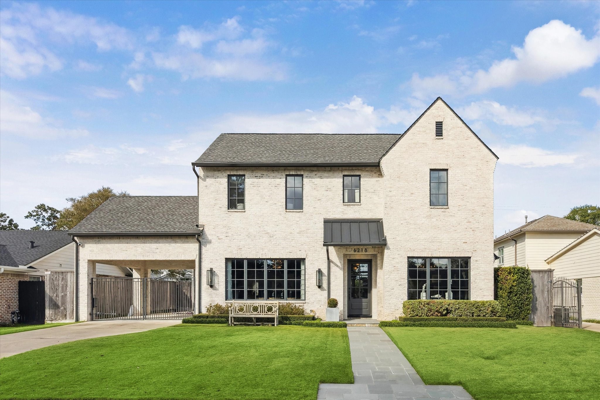 a front view of a house with a yard and trees