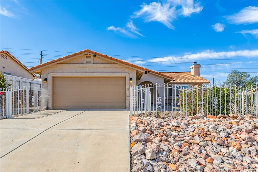 2524 South Ridge Avenue Bullhead City, AZ 86429 - Photo 6 of 64 Ranch-style home featuring a tile roof, stucco siding, a chimney, driveway, and a garage
