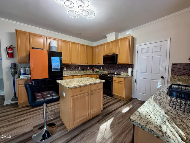 a view of a kitchen with fridge and wooden floor