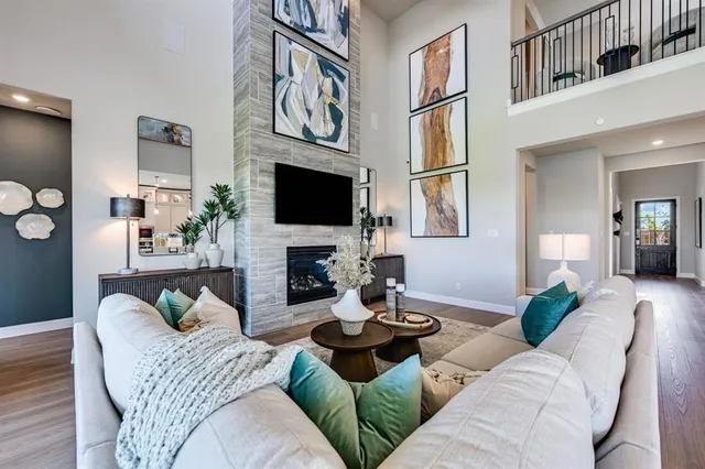 a kitchen with stainless steel appliances kitchen island granite countertop a stove a refrigerator a oven a white table and chairs with wooden floor