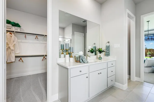 a spacious bedroom with a bed mirror and window