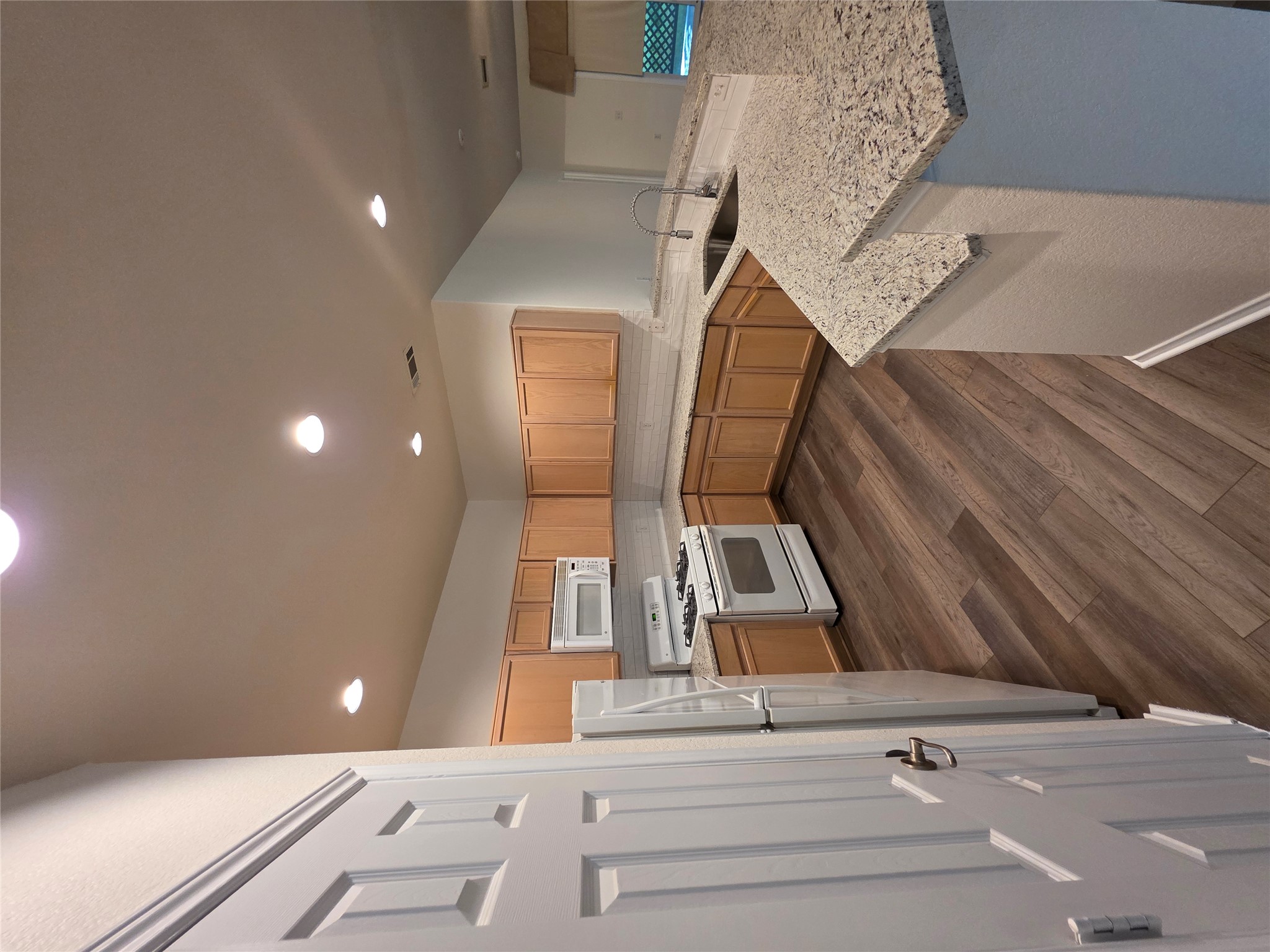 201 Yosemite Road Georgetown, TX 78633 - Photo 7 of 21 Kitchen with stove, dark wood-style flooring, a peninsula, recessed lighting, and light stone countertops