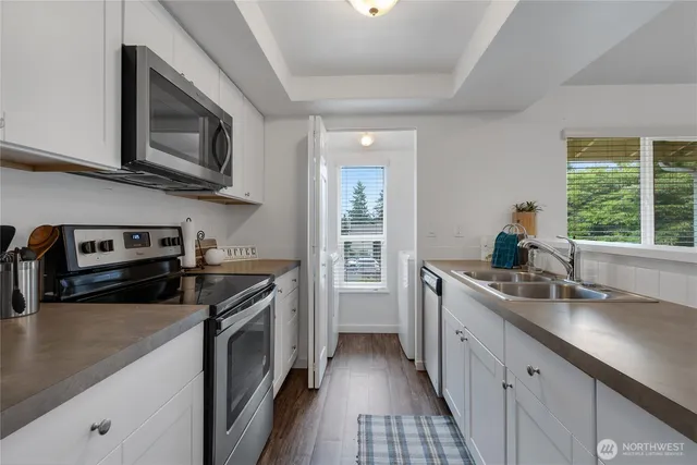 a kitchen with stainless steel appliances granite countertop a sink stove and microwave