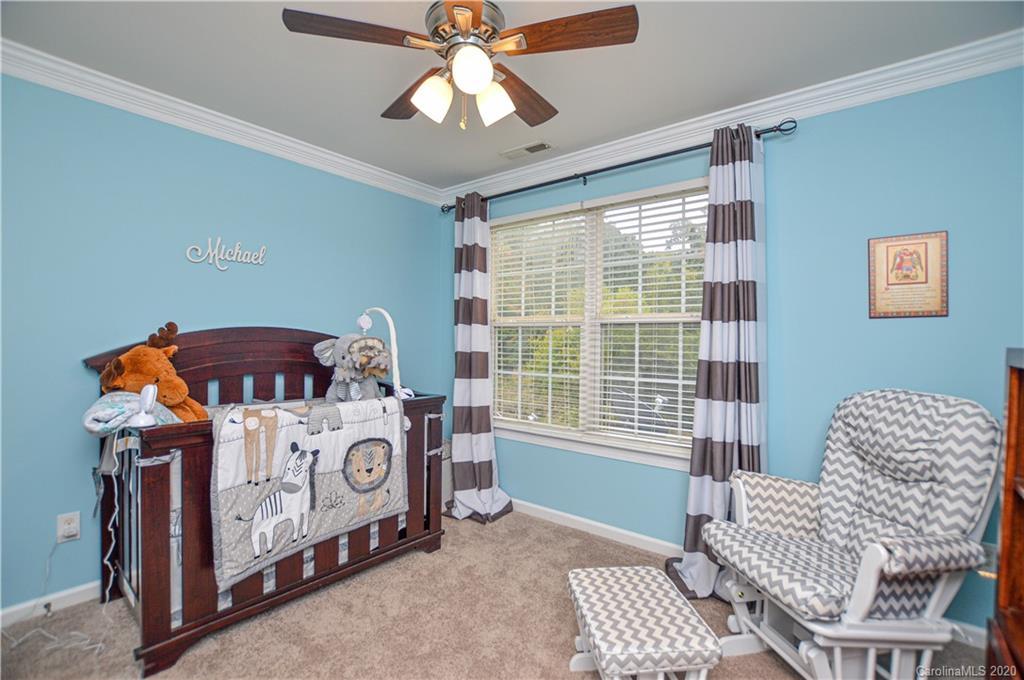 5699 Stafford Road Charlotte, NC 28215 - Photo 14 of 23 a bedroom with a bed and a chandelier