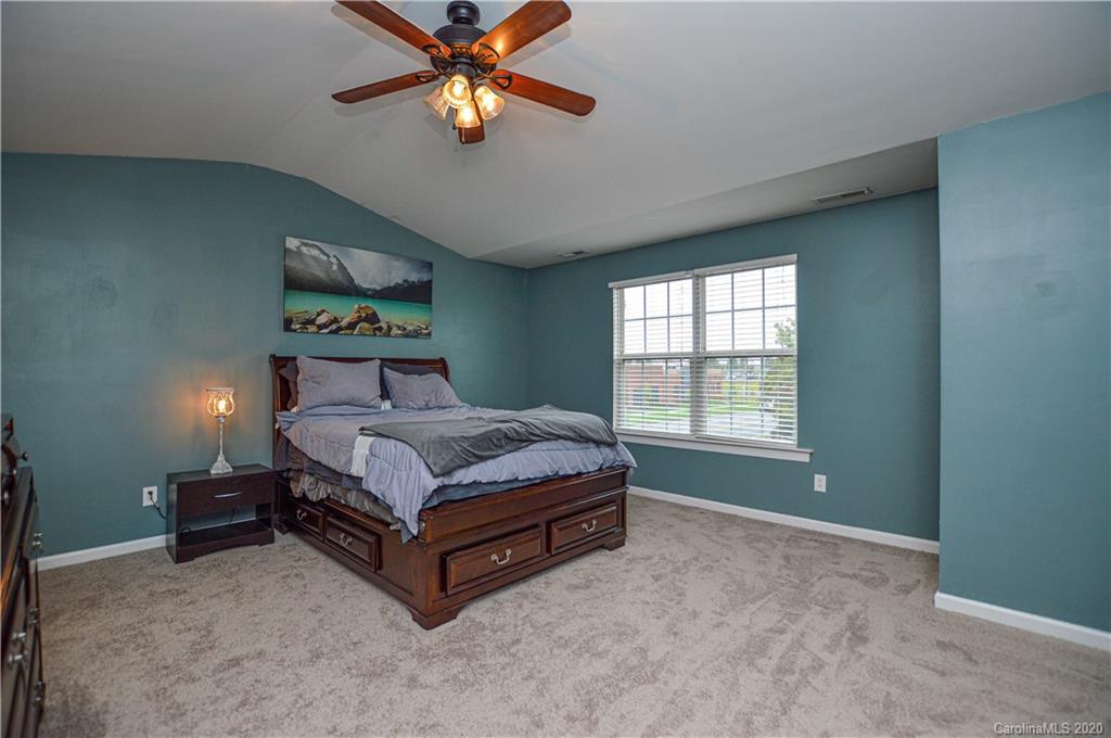 5699 Stafford Road Charlotte, NC 28215 - Photo 18 of 23 a bedroom with a bed and a chandelier