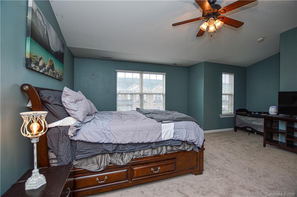 5699 Stafford Road Charlotte, NC 28215 - Photo 19 of 23 a bedroom with a bed and a chandelier