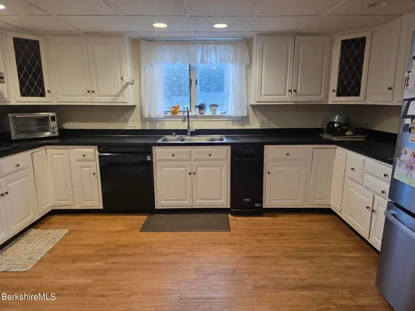 a kitchen with stainless steel appliances granite countertop a stove a sink and white cabinets