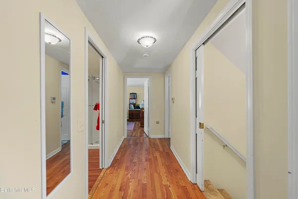 a view of a hallway with wooden floor and staircase