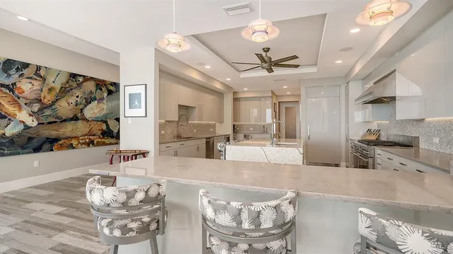 a kitchen with stainless steel appliances kitchen island granite countertop a stove a sink and a refrigerator