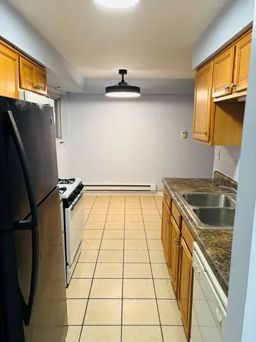 a kitchen with granite countertop a refrigerator and a sink