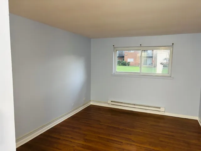 an empty room with wooden floor and a window