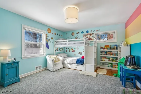 a bedroom with a bed and a painting on the wall