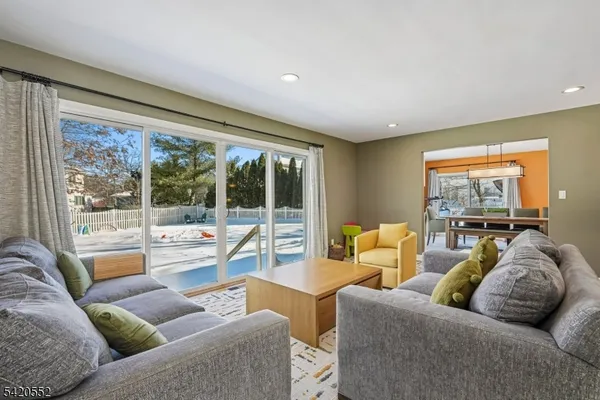 a living room with furniture a rug and a large window