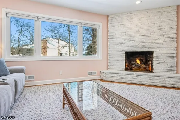 a view of a dining room with furniture a rug and wooden floor