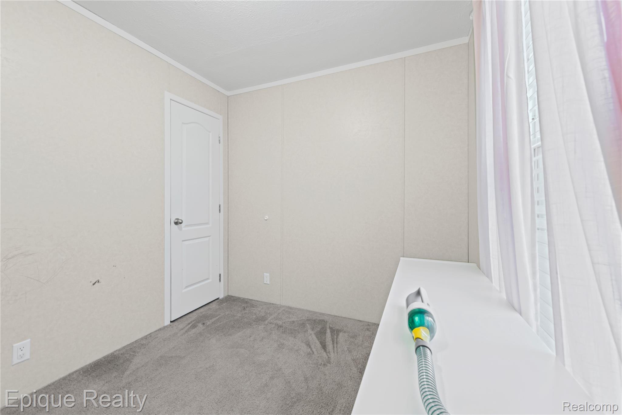 83 Elm Highland, MI 48357 - Photo 13 of 27 Unfurnished room with ornamental molding and light carpet
