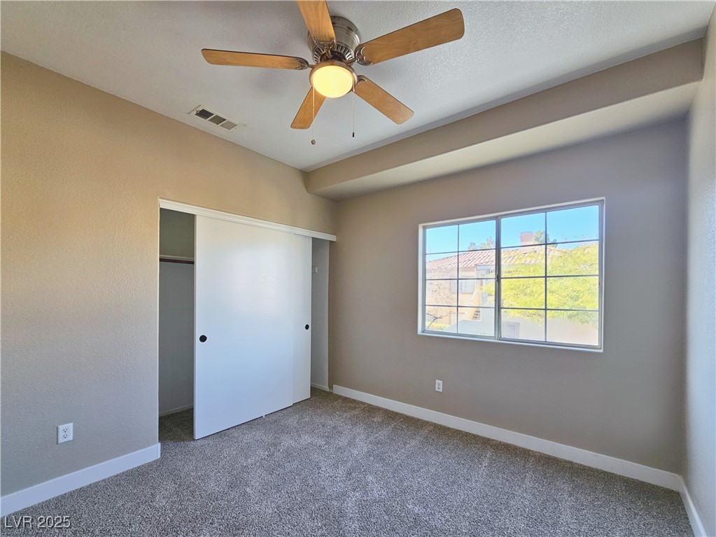 1851 Hillpointe Road, Unit 2124 Henderson, NV 89074 - Photo 20 of 24 Unfurnished bedroom with carpet, a ceiling fan, a closet, visible vents, and baseboards