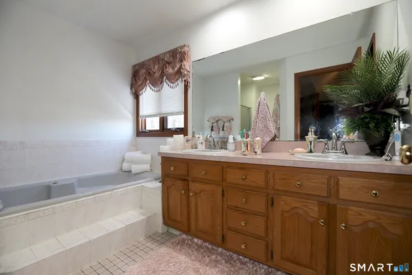 a bathroom with a tub sink and mirror