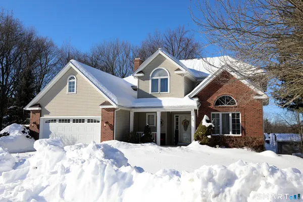 a view of a white house with a yard covered in snow