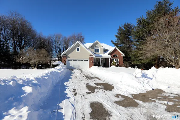 a view of a wooden house with a yard covered in snow