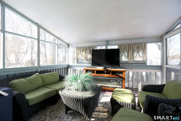 a living room with furniture a flat screen tv and a large window