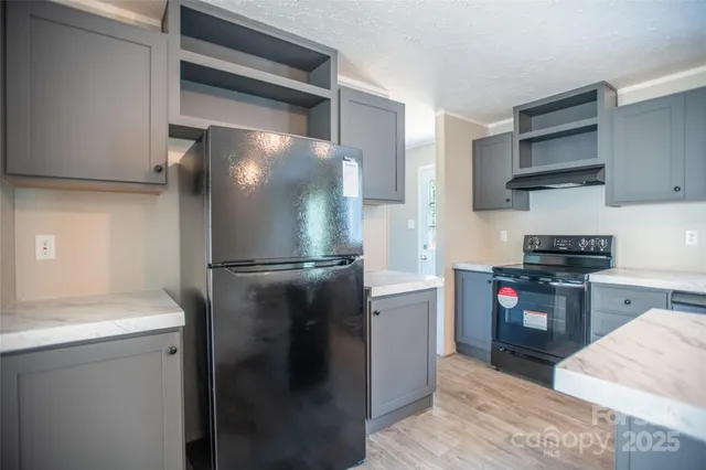 a kitchen with stainless steel appliances granite countertop a refrigerator and a stove top oven