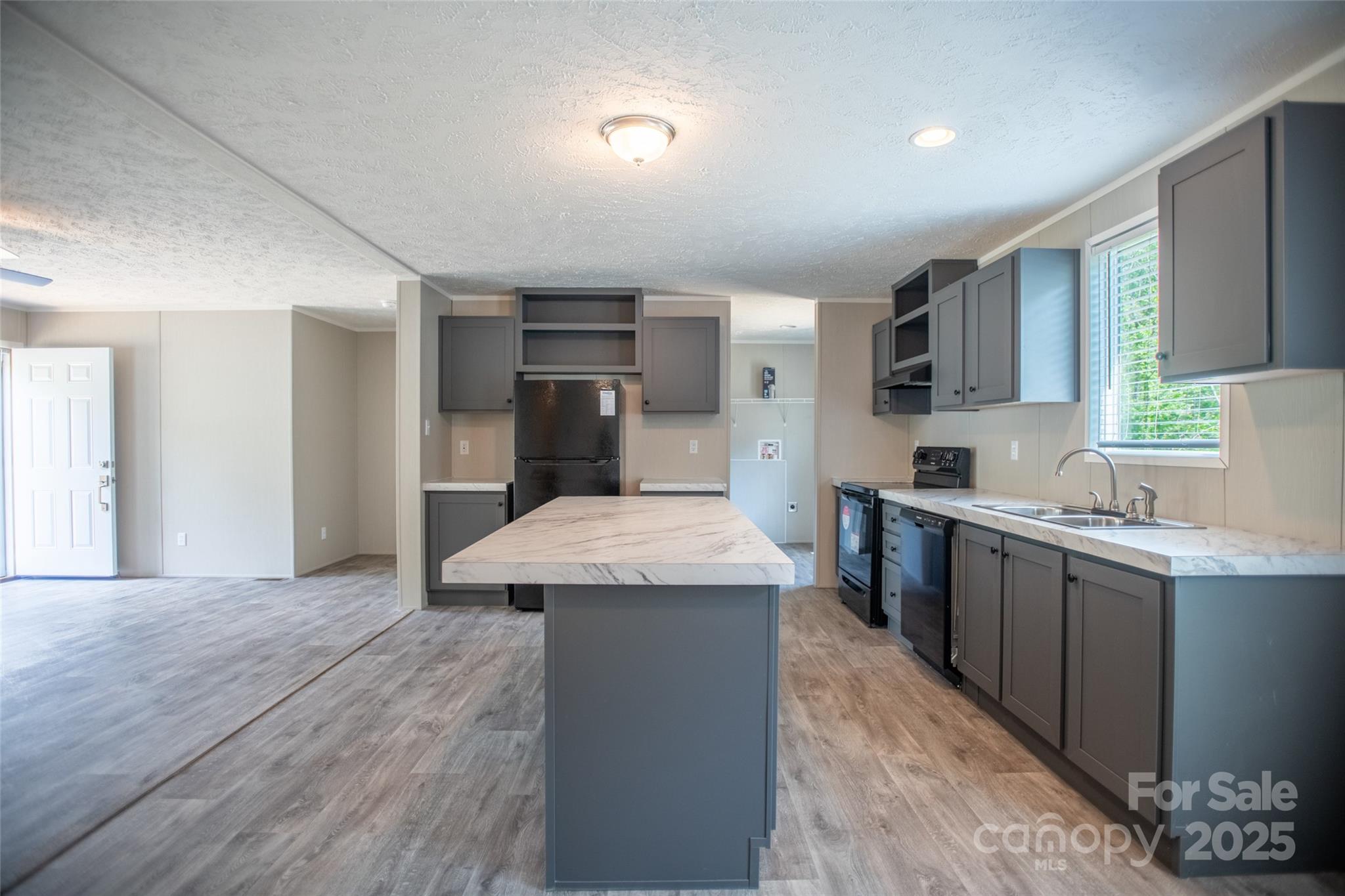 1451 Newfound Road Leicester, NC 28748 - Photo 18 of 39 a kitchen with granite countertop a sink cabinets and wooden floor