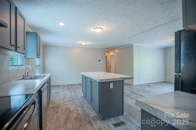 a kitchen with kitchen island a counter top a stove a sink and a refrigerator