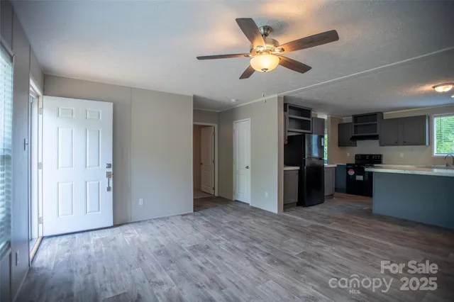 a view of a kitchen with a sink hardwood floor and a ceiling fan