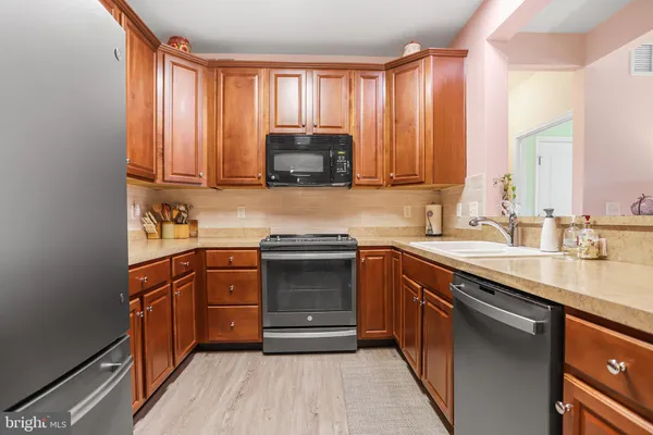 a kitchen with stainless steel appliances granite countertop wooden cabinets a sink and a stove