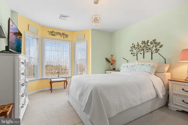 a bedroom with a bed couch and a flat tv screen