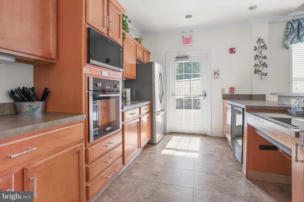 a kitchen that has a lot of cabinets a sink and couches in it